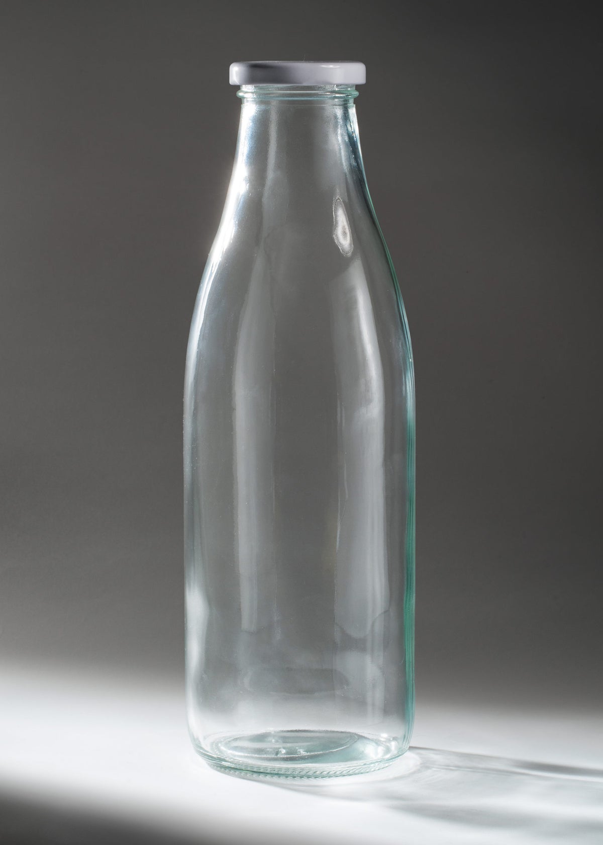 Botella Milky de vidrio transparente con tapa de rosca blanca de 950 ml, vista completa.