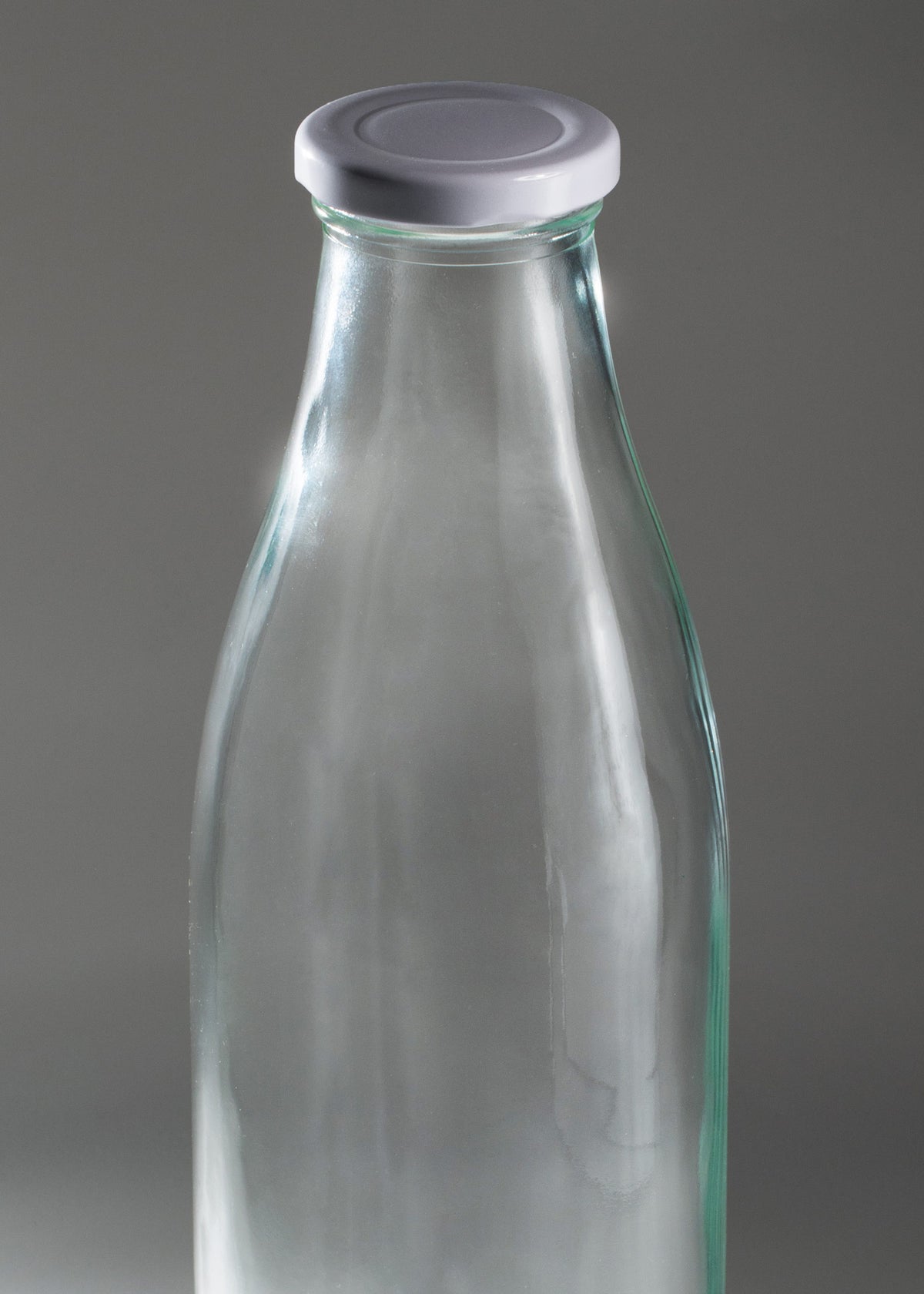 Detalle del cuello y el cuerpo de vidrio transparente de la botella para leche Milky.