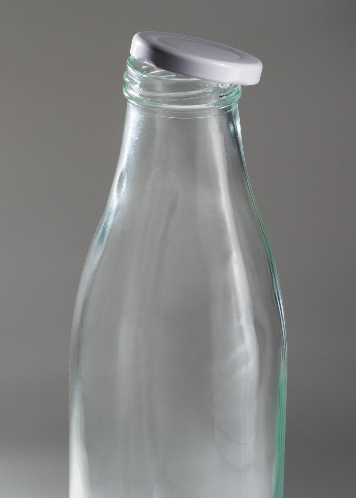 Detalle de la boca de rosca y tapa blanca de la botella Milky de vidrio de 950 ml.
