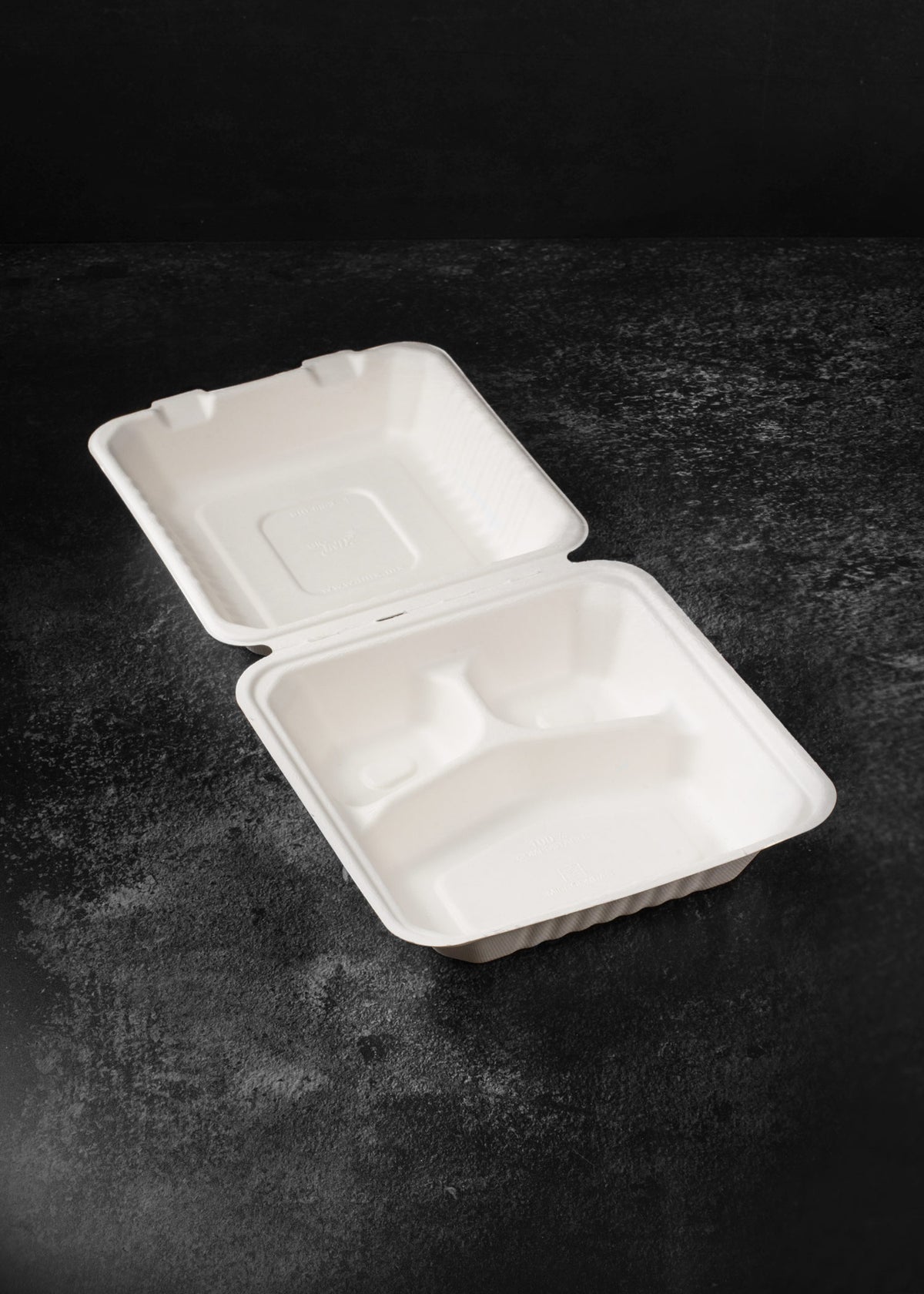 Contenedor compostable abierto que muestra sus tres divisiones para separar alimentos y guarniciones.