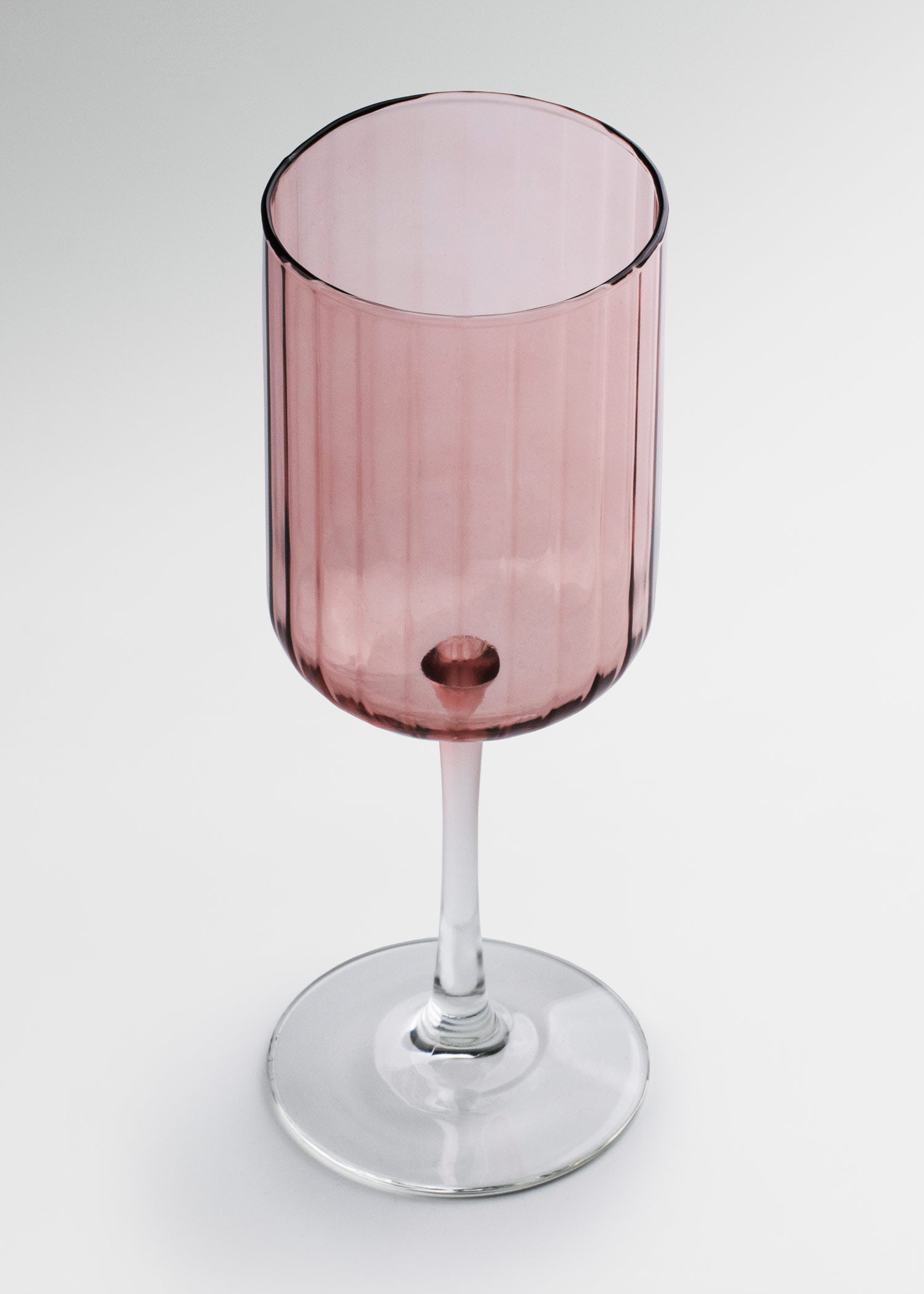 Copa de vidrio rosa con cáliz alto y tallo largo
