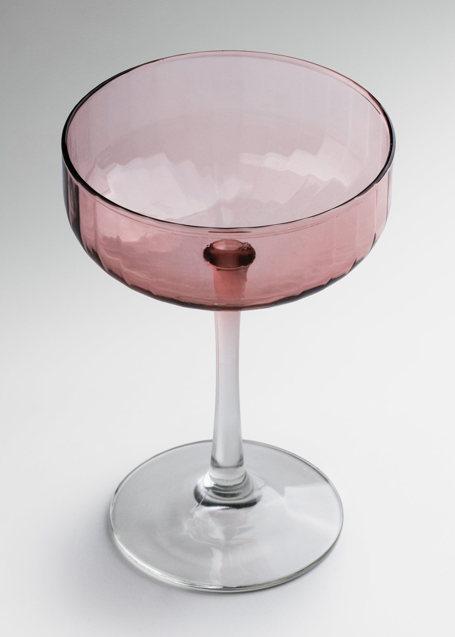 Copa de vidrio rosa con cáliz ancho para cócteles