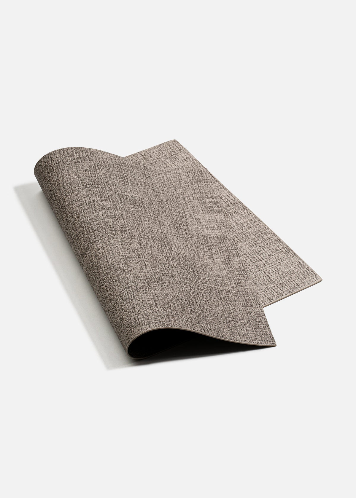 Mantel individual de vinilo gris parcialmente enrollado para mostrar su flexibilidad.
