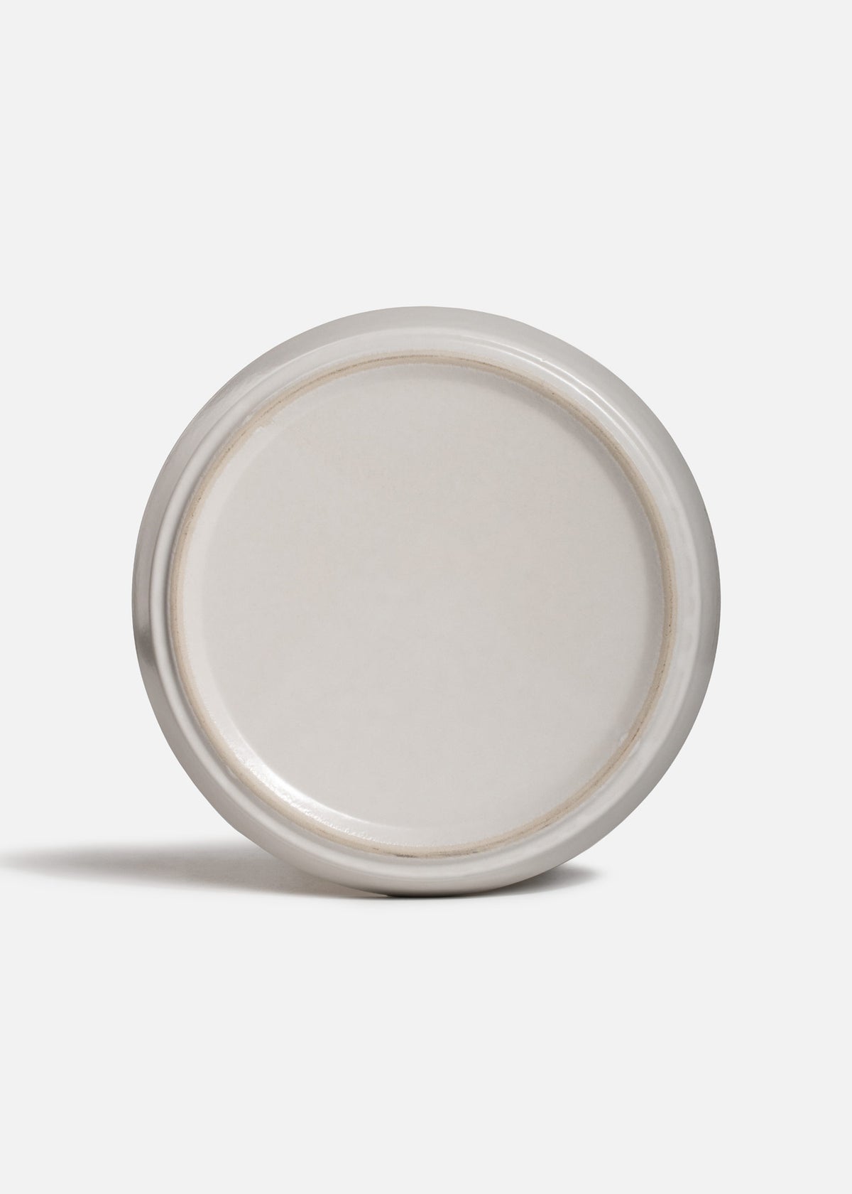 Vista posterior y base circular del plato Cuarzo Gris de porcelana.