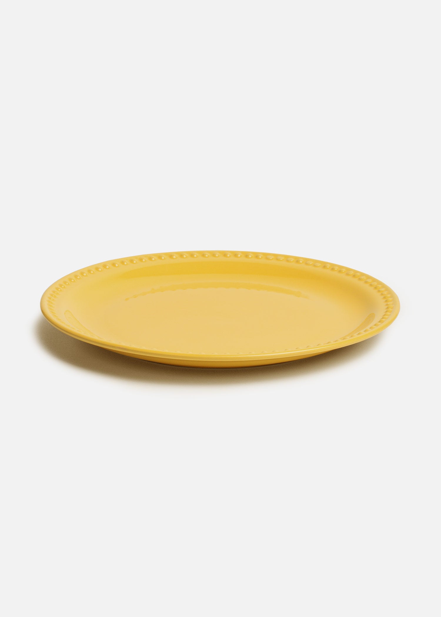 Detalle del borde en relieve del plato Monet amarillo