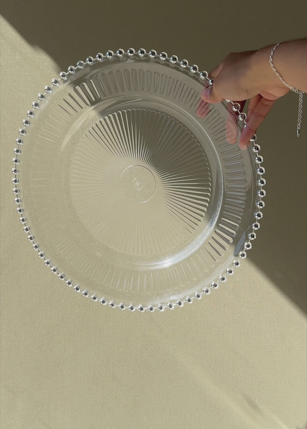 Cargar vídeo: Video de Plato base de vidrio transparente con filo plata Perla Ø 32 cm para banquetes, hoteles, restaurantes, bodas y eventos