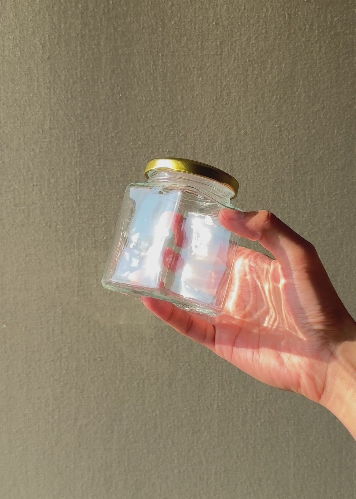Cargar vídeo: Video con luz natural del frasco de vidrio transparente con tapa dorada de 200 ml.