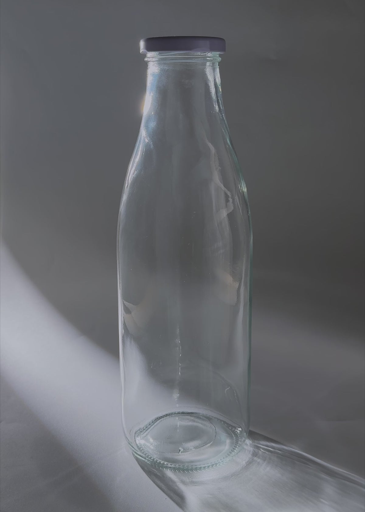 Cargar vídeo: Video de estudio de la botella Milky de vidrio transparente con tapa de rosca de 950 ml.