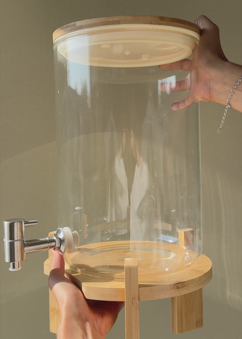 Video en luz natural del dispensador transparente de 8 litros con tapa de bambú.