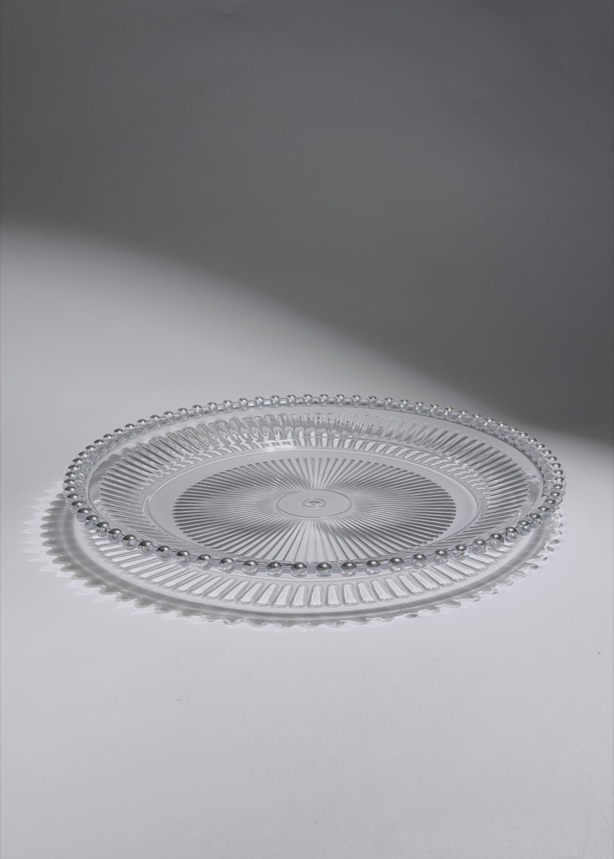 Cargar vídeo: Video de Plato base de vidrio transparente con filo plata Perla Ø 32 cm para banquetes, hoteles, restaurantes, bodas y eventos