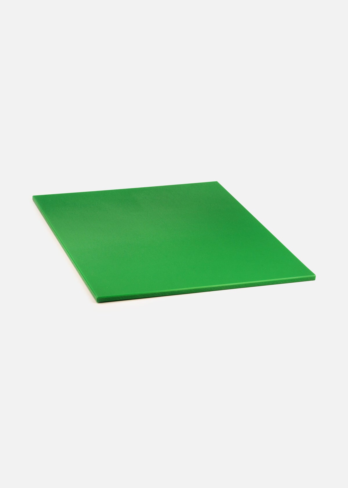 Tabla de corte verde de polietileno vista en ángulo, con su superficie y borde visibles.