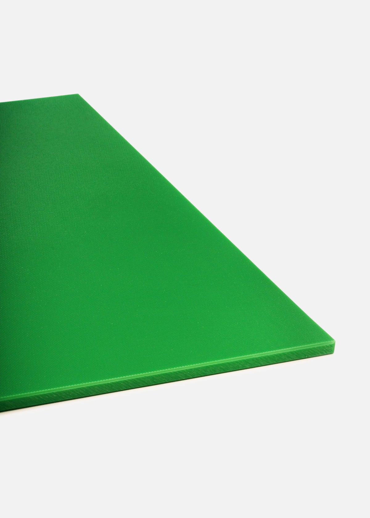 Detalle de la textura y el borde de la tabla de corte de polietileno verde.