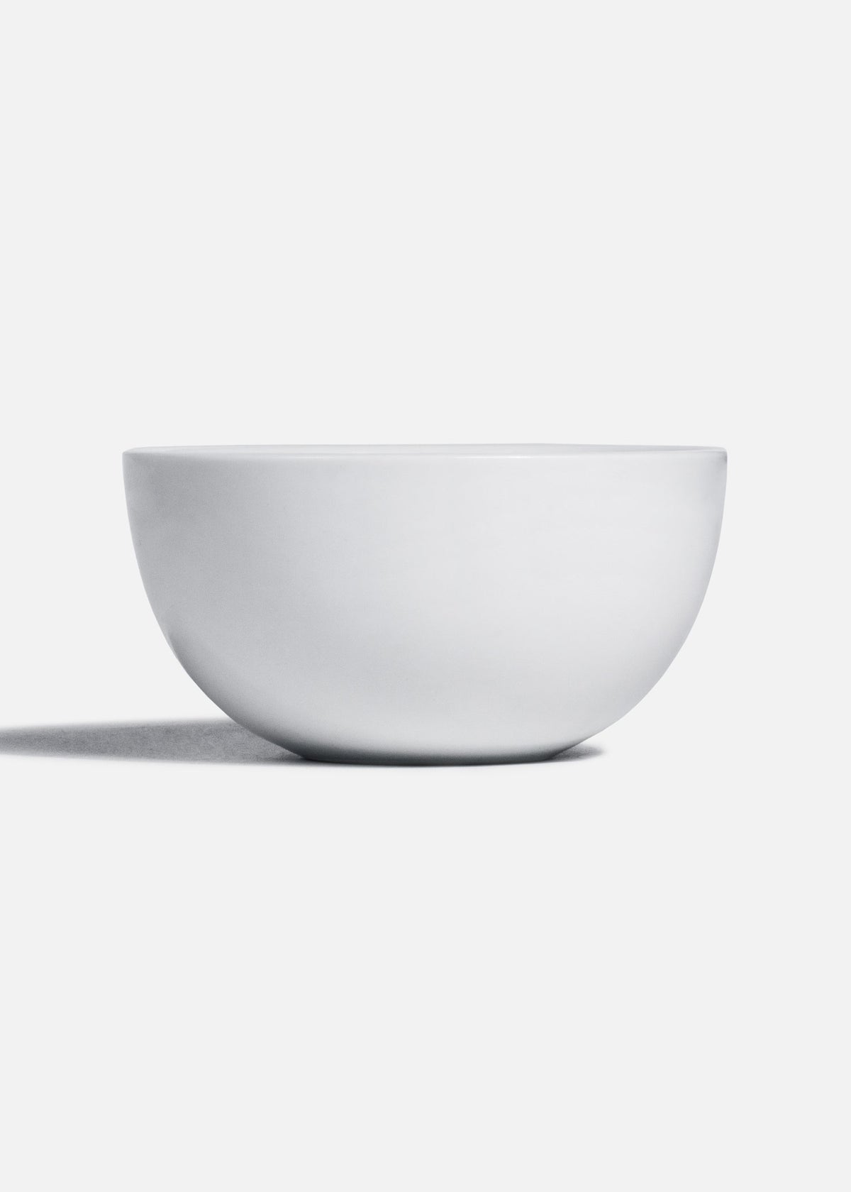 Perfil de taza para consomé de porcelana blanca con base circular.