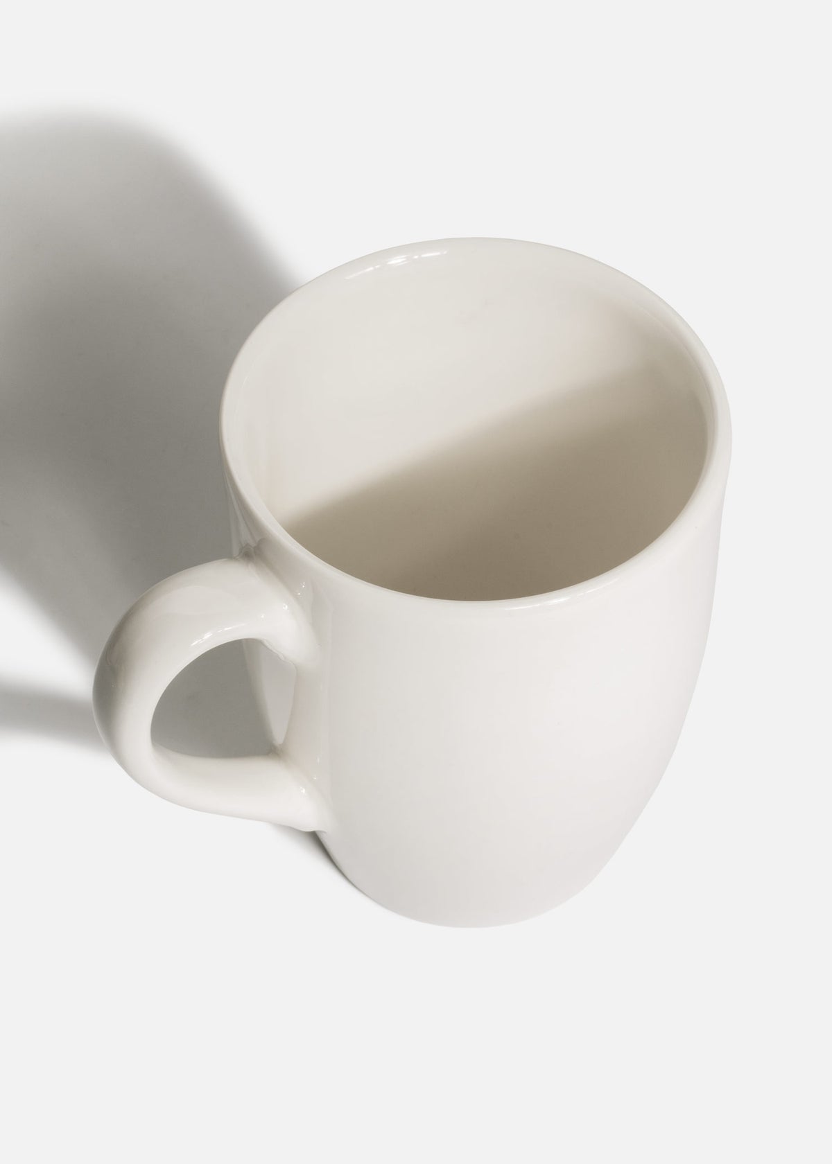 Taza blanca de porcelana con cuerpo cónico y asa