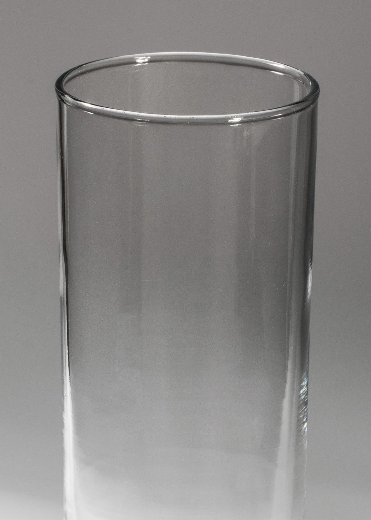 Detalle del borde circular y paredes lisas de vaso highball de vidrio.