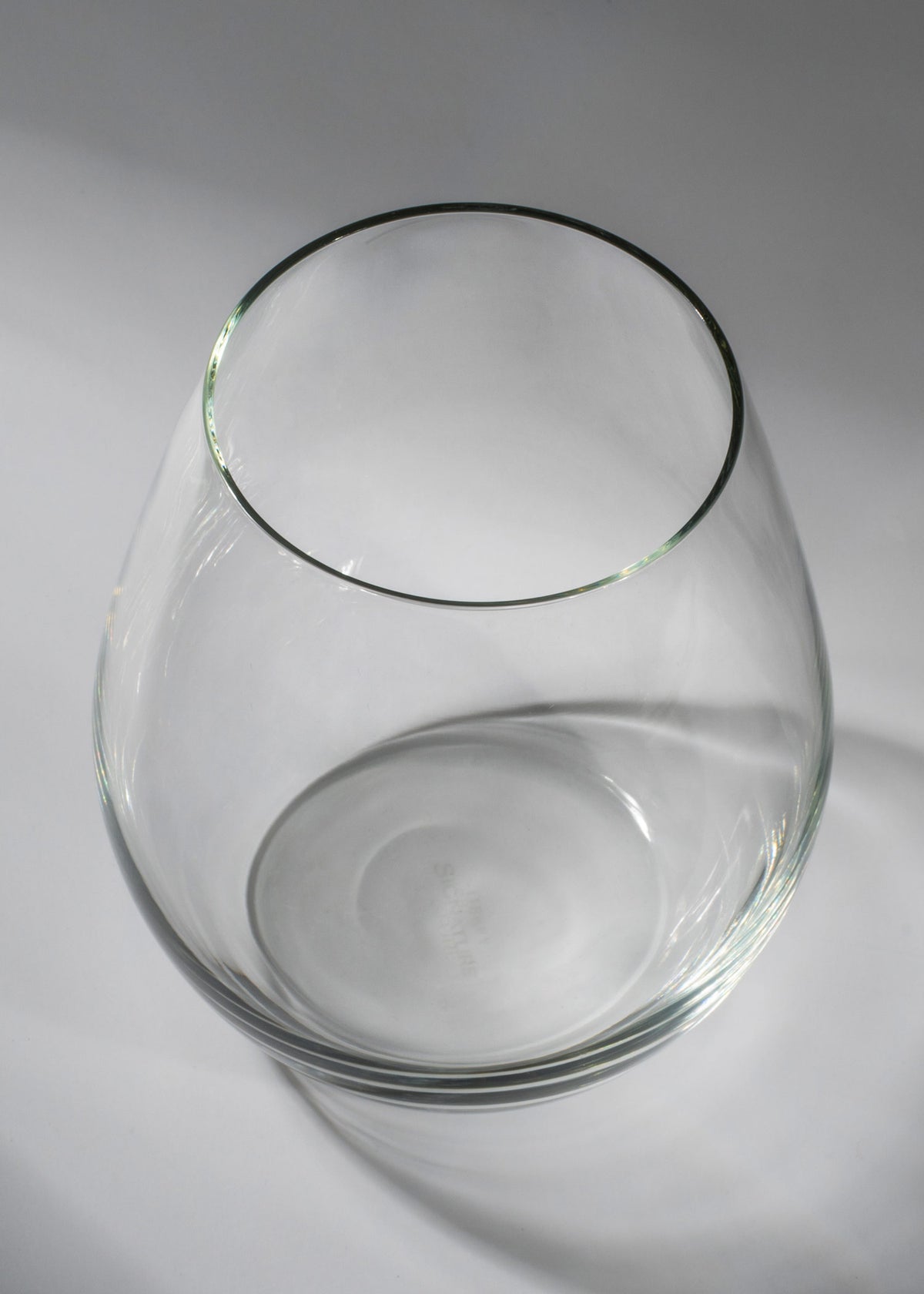 Vista superior del vaso transparente de cuerpo abombado y boca circular.